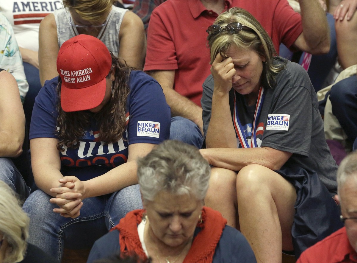 President Donald Trump supporters bow their heads and pray before a campaign rally Thursday, May 10, 2018, in Elkhart, Ind. (AP Photo/Charles Rex Arbogast)