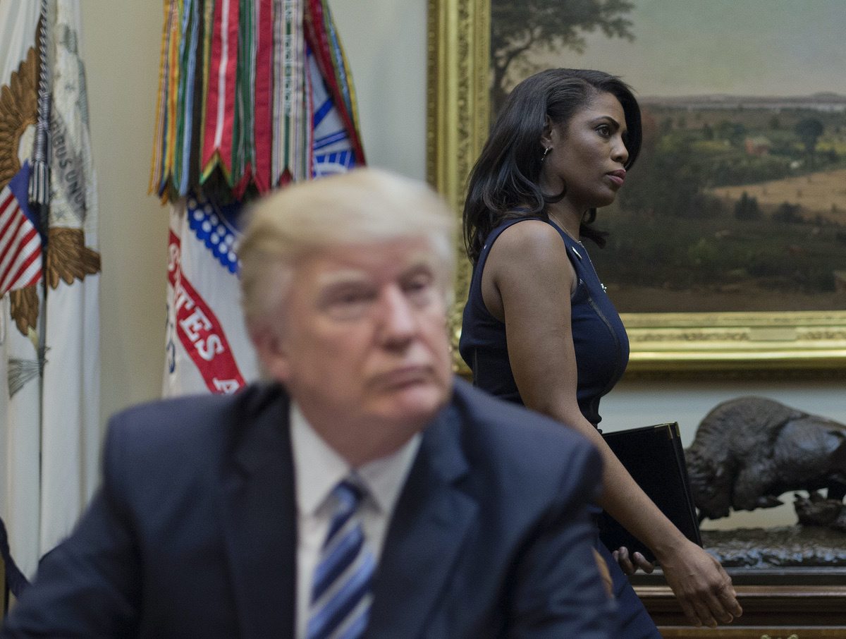 Omarosa Manigault, right, walks past President Donald Trump during a meeting on healthcare in the Roosevelt Room of the White House in Washington, Monday, March 13, 2017. (AP Photo/Pablo Martinez Monsivais)