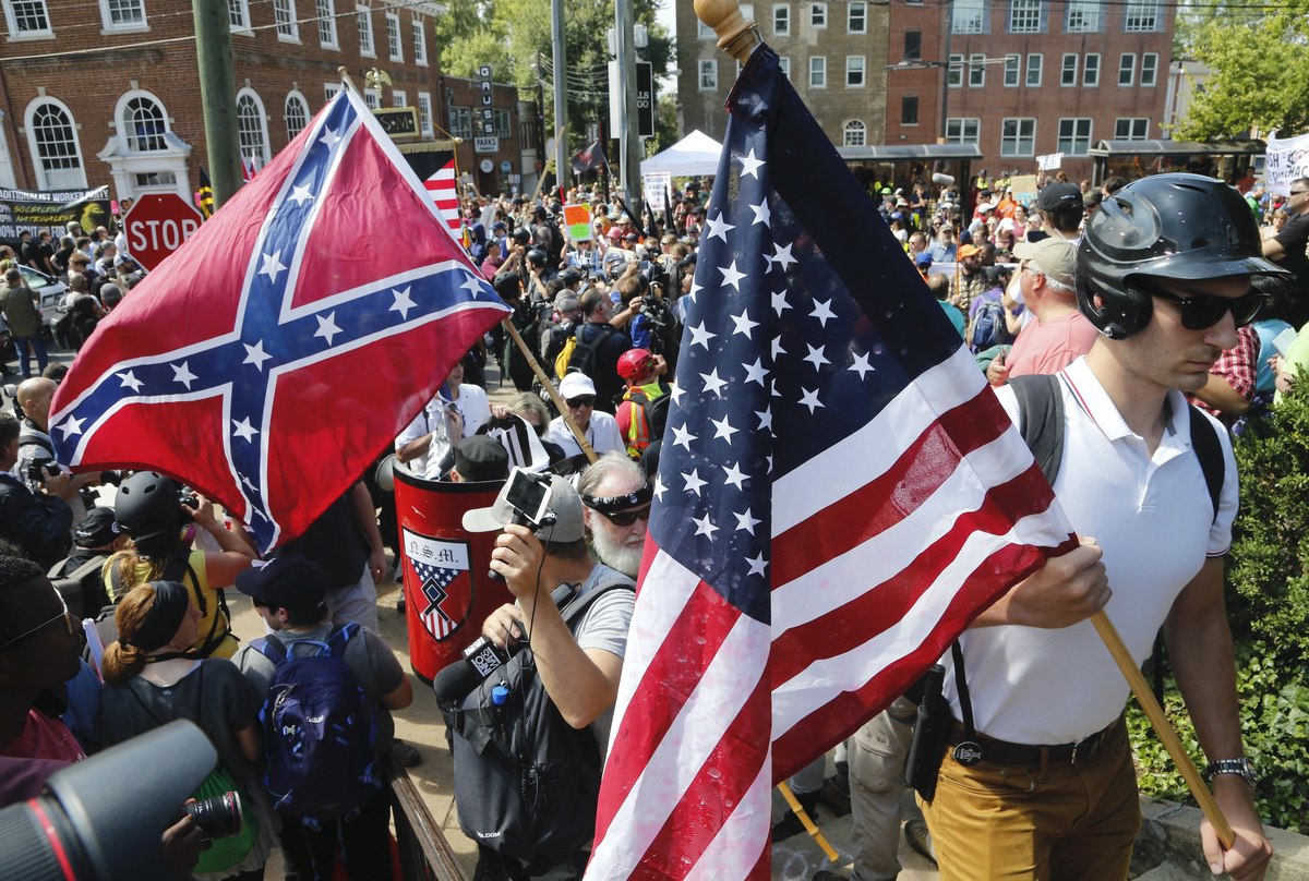 White supremacists walk into Lee park surrounded by counter demonstrators in Charlottesville, VA — Saturday, Aug. 12, 2017 (AP Photo/Steve Helber)